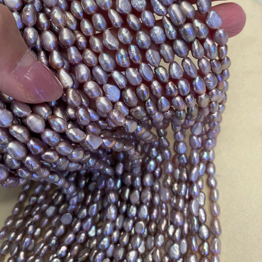 Lila Süßwasserperlen Strang – Natürliche Reisperlen mit irisierendem Glanz, unregelmäßige Nuggetform, seitlich gebohrt, ca. 36 cm lang