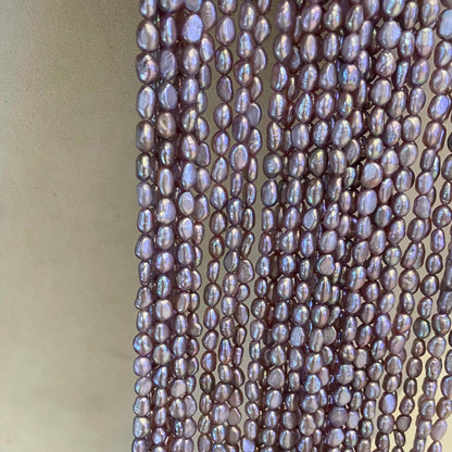 Lila Süßwasserperlen Strang – Natürliche Reisperlen mit irisierendem Glanz, unregelmäßige Nuggetform, seitlich gebohrt, ca. 36 cm lang