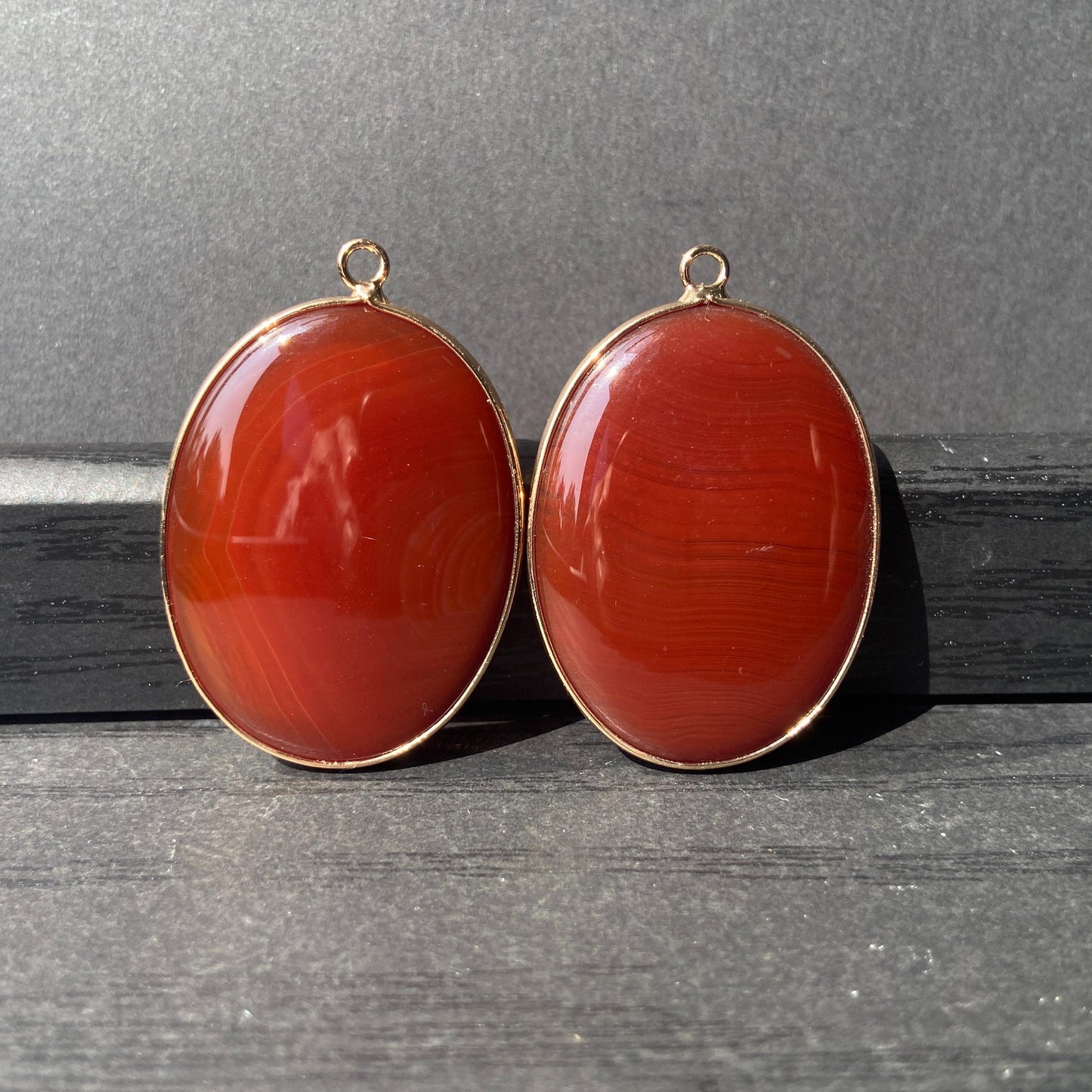 Handgeschliffener ovaler Naturstein Anhänger aus rotem Achat mit goldfarbener Fassung für DIY Schmuckherstellung und Boho Halsketten