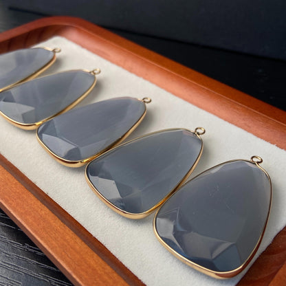 Facettierter grauer synthetischer Katzenauge Kristall Anhänger mit goldfarbener Fassung für DIY Schmuckherstellung und Boho Schmuckdesign