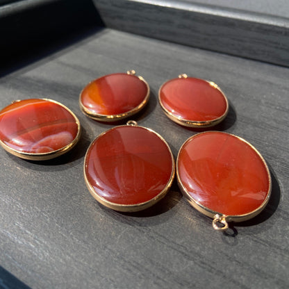 Handgeschliffener ovaler Naturstein Anhänger aus rotem Achat mit goldfarbener Fassung für DIY Schmuckherstellung und Boho Halsketten