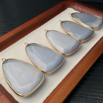 Facettierter grauer synthetischer Katzenauge Kristall Anhänger mit goldfarbener Fassung für DIY Schmuckherstellung und Boho Schmuckdesign