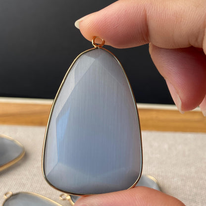 Facettierter grauer synthetischer Katzenauge Kristall Anhänger mit goldfarbener Fassung für DIY Schmuckherstellung und Boho Schmuckdesign