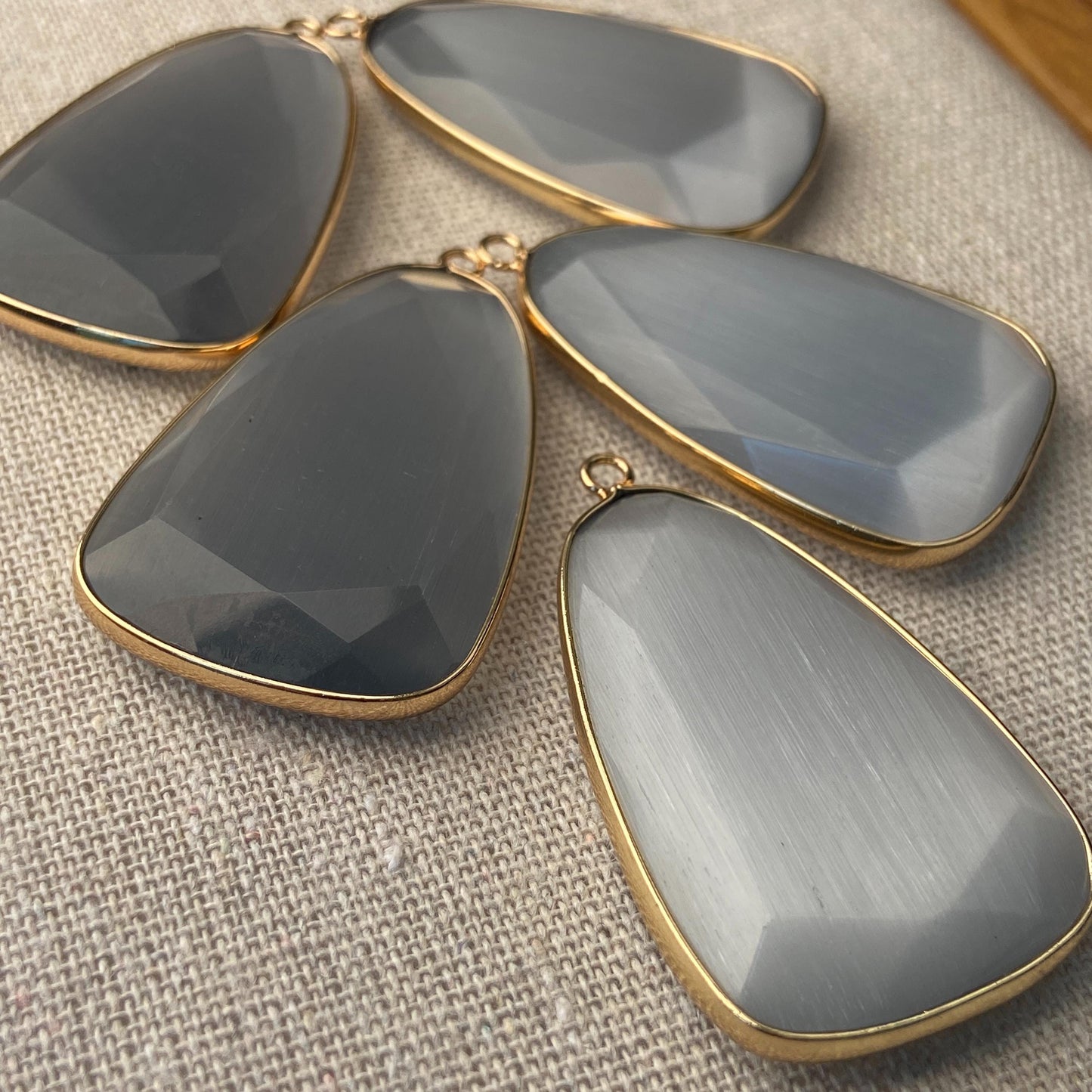 Facettierter grauer synthetischer Katzenauge Kristall Anhänger mit goldfarbener Fassung für DIY Schmuckherstellung und Boho Schmuckdesign