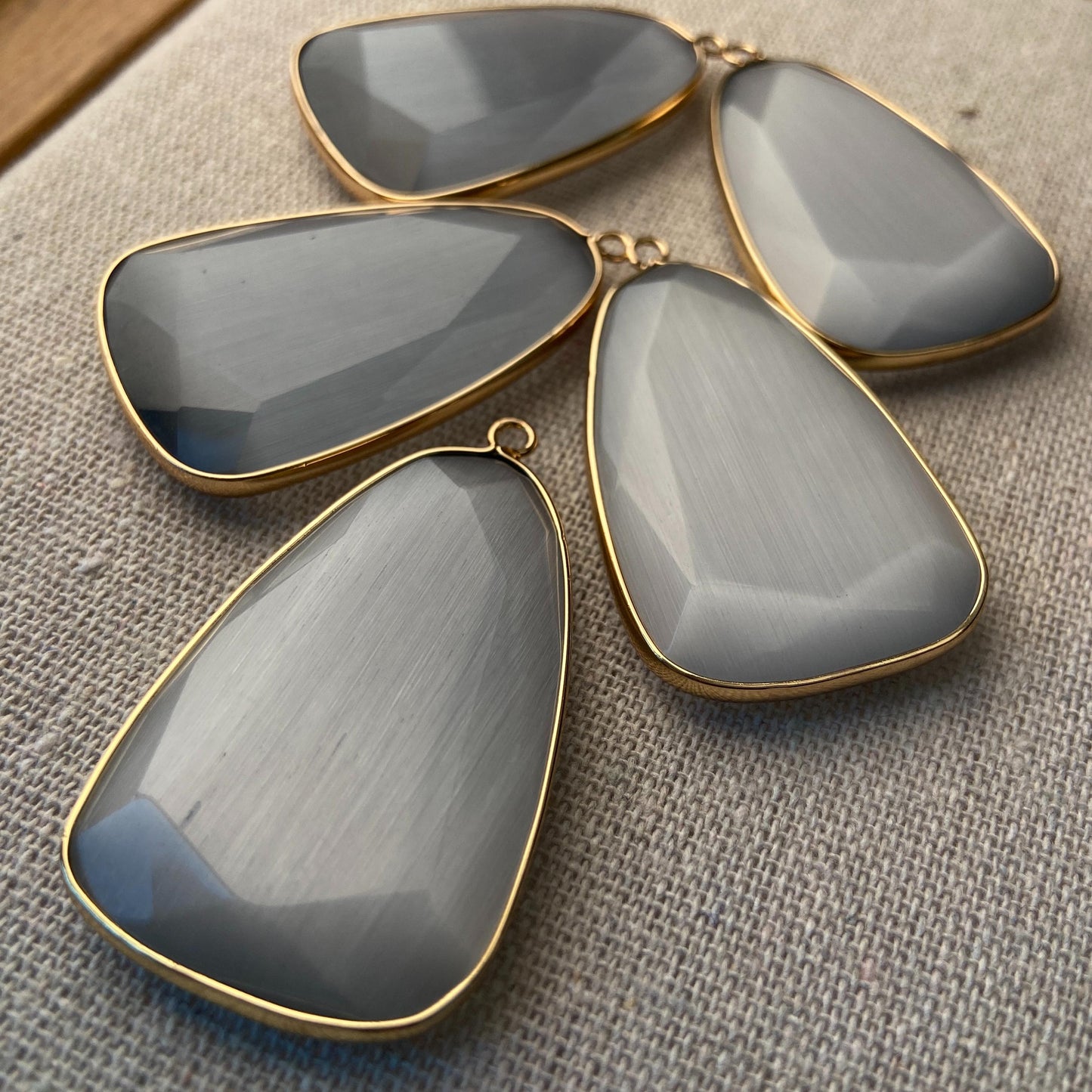 Facettierter grauer synthetischer Katzenauge Kristall Anhänger mit goldfarbener Fassung für DIY Schmuckherstellung und Boho Schmuckdesign