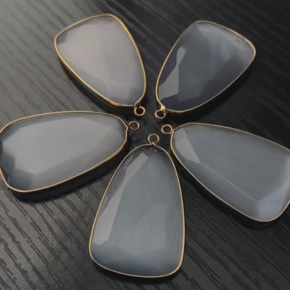 Facettierter grauer synthetischer Katzenauge Kristall Anhänger mit goldfarbener Fassung für DIY Schmuckherstellung und Boho Schmuckdesign